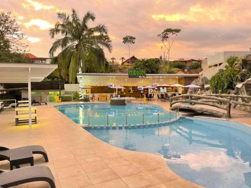 a large swimming pool in front of a shopping mall at Hotel PZ Country Club & Conference Center in San Isidro