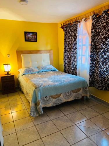 a bedroom with a bed in a yellow room at El paraíso de Zacatlán DEPARTAMENTO con JARDÍN, 11 pax in Zacatlán