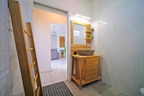 uma casa de banho com um lavatório e um espelho em La Villa Belle Lézarde em Petit-Bourg