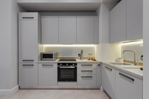 a kitchen with white cabinets and a stove top oven at NEW! Luxury apartment in the CENTER of ODESSA overlooking Deribasovskaya str. LOW PRICE! in Odesa