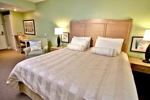 una camera d'albergo con un grande letto e una sedia di Holly Tree Resort, a VRI resort a West Yarmouth