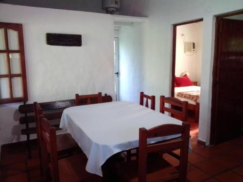 een slaapkamer met een tafel en stoelen en een bed bij EL PASO IBERA in Colonia Carlos Pellegrini