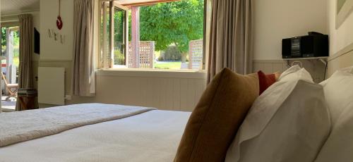 a bedroom with a white bed with a window at Burn Cottage Retreat in Cromwell