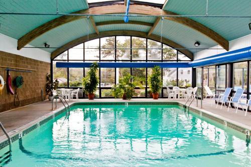 a swimming pool in a building with a large window at Holly Tree Resort, a VRI resort in West Yarmouth