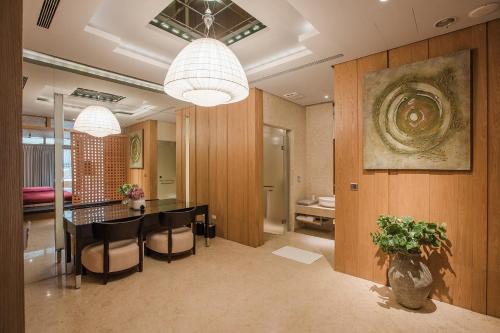 a dining room with a table and chairs and a painting at Motel Stars in Taichung