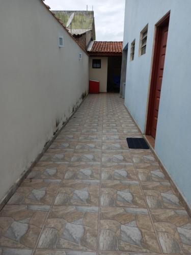 a corridor between two buildings with a tiled floor at Casa Azul no Centro Ilha Comprida in Ilha Comprida