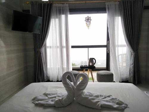 two swansuitsrendered to look like hearts sitting on a bed at Batur view Homestay - Loft in Kintamani