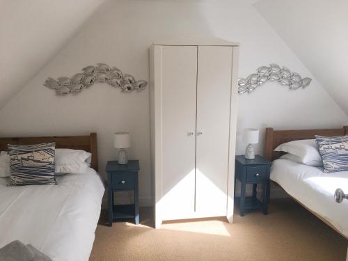 a bedroom with two beds and a white cabinet at 85 Seatown in Cullen
