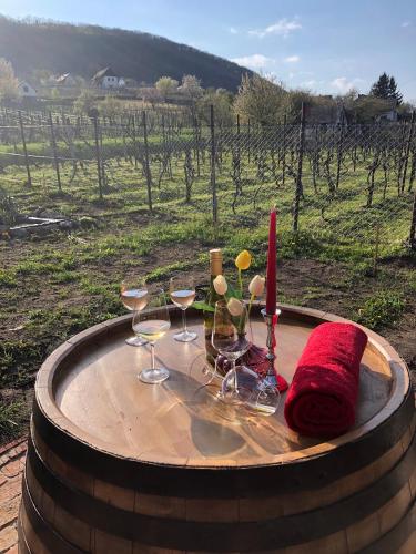 a wooden barrel with wine glasses and a red towel at Rubin in Doba