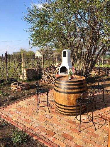 a barrel with a table and chairs on a brick patio at Rubin in Doba