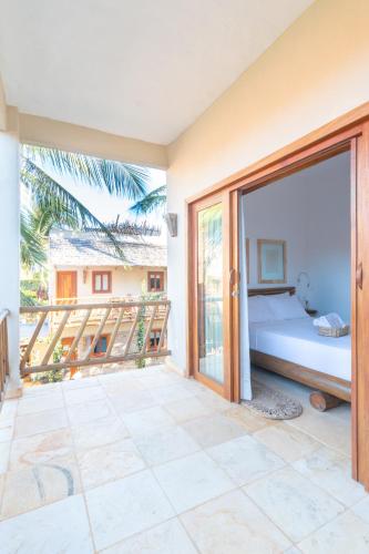 a bedroom with a bed and a balcony at CasaLô Hotel in Jericoacoara
