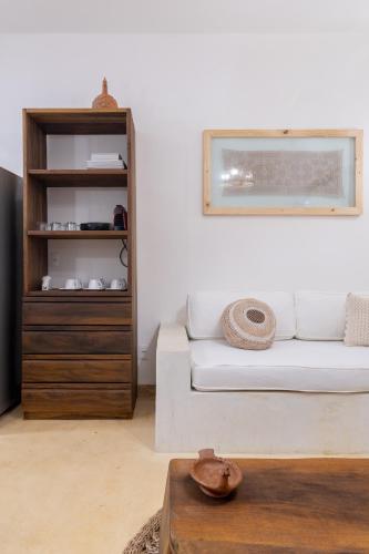 a living room with a white couch and a shelf at CasaLô Hotel in Jericoacoara