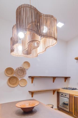 a kitchen with a table with a bowl and a chandelier at CasaLô Hotel in Jericoacoara