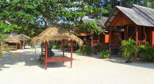a building with a straw umbrella on the beach at Nice Sea Resort in Srithanu