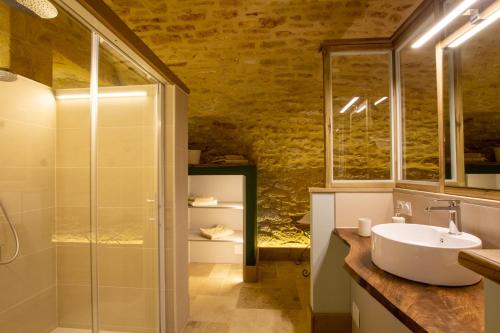 a bathroom with a glass shower and a sink at Le Clos de la Tour in Sainte-Nathalène