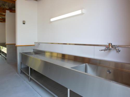 a kitchen with stainless steel sinks in a room at Matsue Forest Park in Matsue
