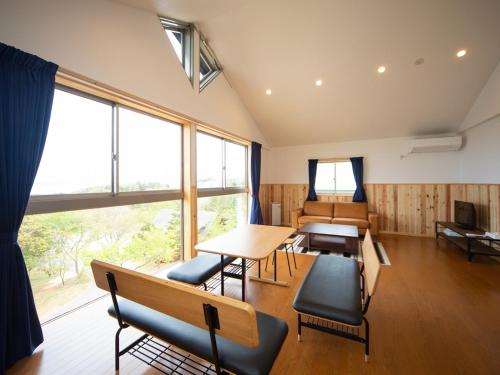a room with tables and chairs and a large window at Matsue Forest Park in Matsue