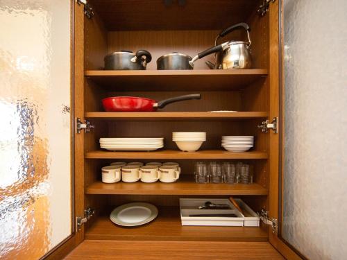a cupboard with dishes and pots and pans at Matsue Forest Park in Matsue