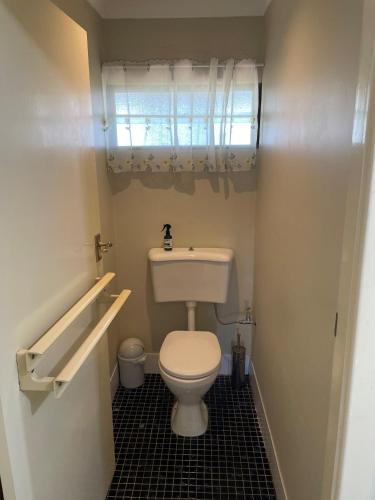 a small bathroom with a toilet and a window at Blueberry Hill Vineyard Stay in Rothbury