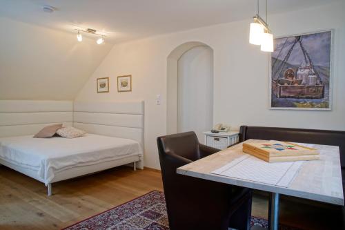 um quarto com uma cama e uma secretária com uma mesa em Appartements Stocker - Zur Schmiede em Schladming