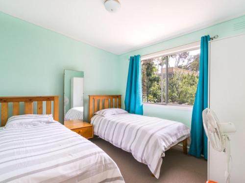 two beds in a room with a window at Summer In Blairgowrie in Blairgowrie