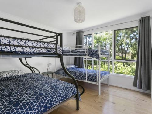 a bedroom with two bunk beds and a window at Woodlands Retreat Rye in Rye