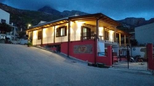 a red and white house with the lights on at A Casa di Amy in Macari