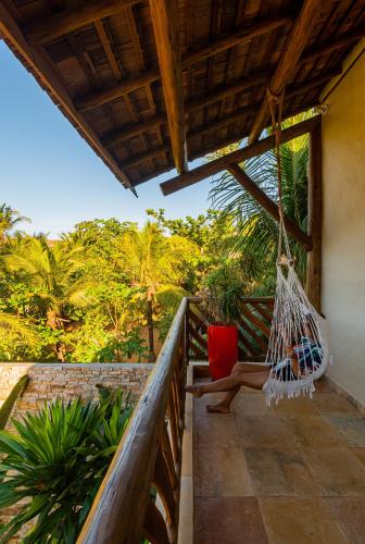 a person sitting in a hammock on a porch at VillaMag in Jericoacoara