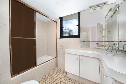 a bathroom with a shower and a sink and a tub at BreakFree Acapulco in Gold Coast