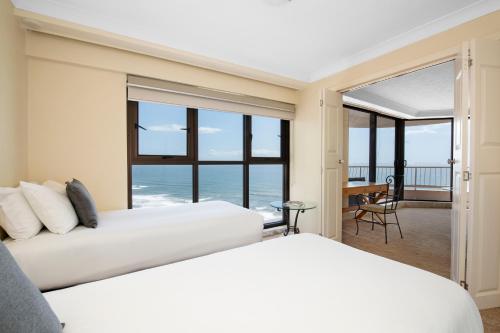 two beds in a bedroom with a view of the ocean at BreakFree Acapulco in Gold Coast