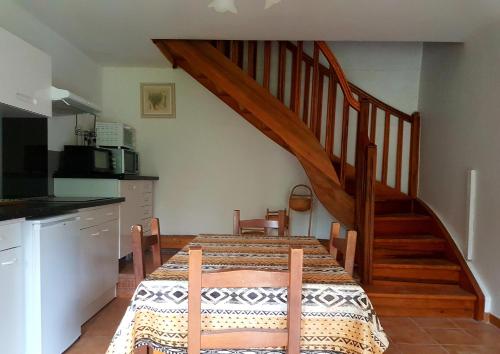 a dining room with a table and a staircase at Charmant appartement dans corps de ferme AIGLUN in Aiglun
