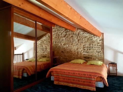 a bedroom with two beds and a mirror at Charmant appartement dans corps de ferme AIGLUN in Aiglun