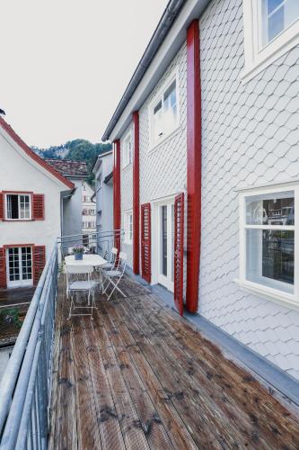 a wooden deck with a table on the side of a house at HEINRICH Stadtwohnung im Jüdischen Viertel in Hohenems