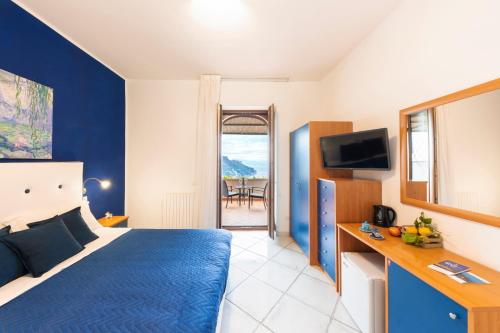 a hotel room with a blue bed and a television at A Due Passi in Ravello