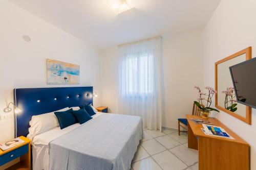 a bedroom with a large bed and a tv at A Due Passi in Ravello
