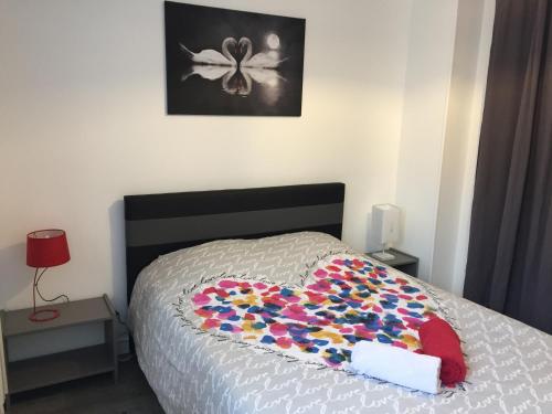 - une chambre avec une couverture en forme de cœur sur un lit dans l'établissement Gîte La Lexovienne Lisieux Centre, à Lisieux