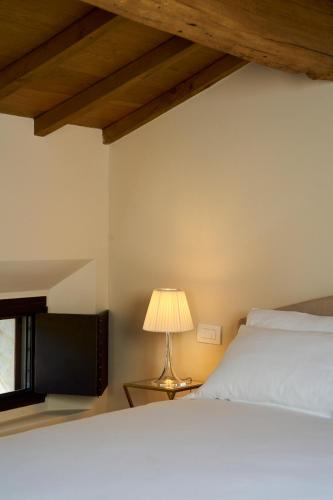 a bedroom with a white bed and a lamp at Casa Gugù in Ravenna