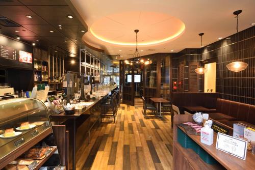 a restaurant with a long counter with tables and chairs at Hakata Green Hotel Tenjin in Fukuoka