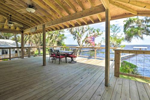 a wooden deck with a table and chairs on it at Renovated Crescent Lake Escape with Waterfront Deck! in Crescent City