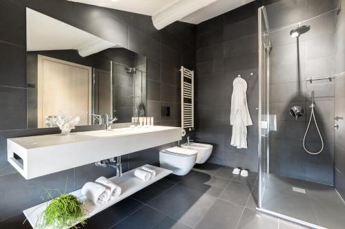 a bathroom with a sink and a toilet and a shower at Hotel Lago Di Garda in Nago-Torbole
