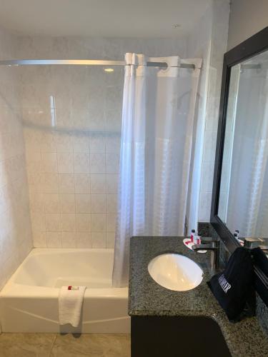 a bathroom with a tub and a sink and a bath tub at Skyways Hotel in Los Angeles