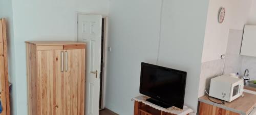 a living room with a flat screen tv next to a door at Larida Vendégház in Sarud