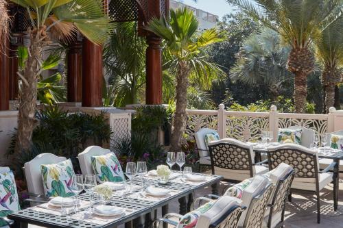 a restaurant with tables and chairs and palm trees at Jumeirah Dar Al Masyaf Dubai in Dubai