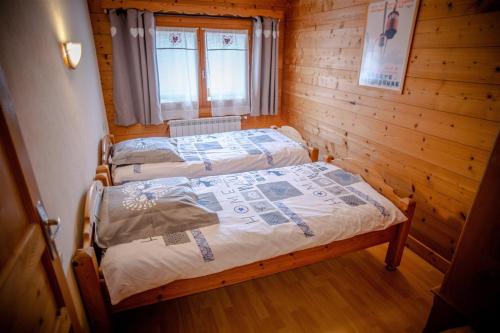 a bedroom with two beds in a wooden cabin at Le Mont Blanc (Gite Des Alpes) in La Giettaz