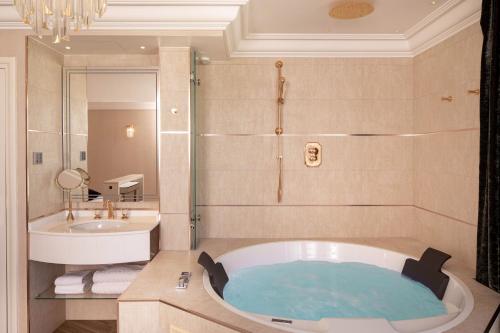 a bathroom with a tub and a sink at Paris j'Adore Hotel & Spa in Paris