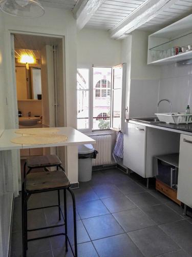 une cuisine avec un comptoir et une table à l'intérieur dans l'établissement Appartement cosy rue Sainte Madeleine, à Strasbourg