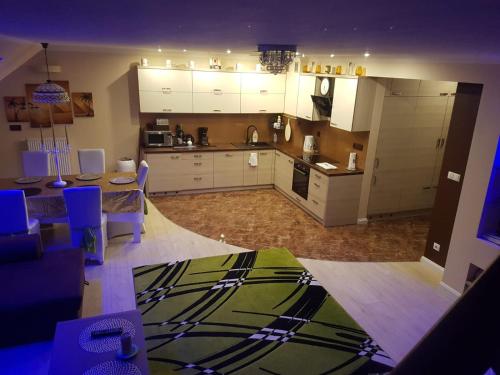 a kitchen and living room with white cabinets and a table at Rodzinny ,Luksusowy Apartament nad jeziorem w centrum Mragowa in Mrągowo