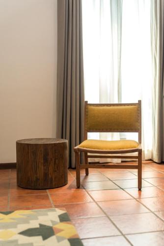 a chair and a stool in a room with a window at Hotel Roadhouse, Thamel, Kathmandu- Contemporary Boutique in Kathmandu