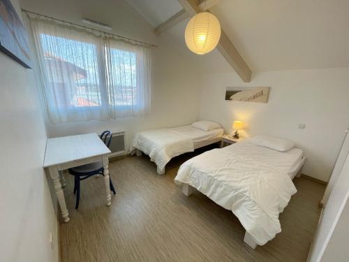 ビスカロッスにある301 RÉSIDENCE ANTINEA -017のベッド2台、デスク、窓が備わる客室です。