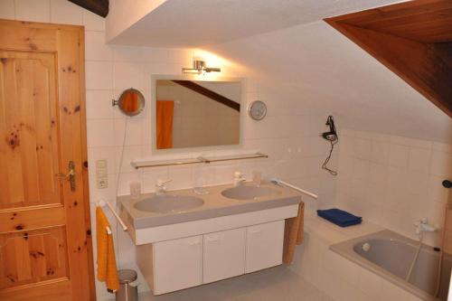 Un baño con lavabo, bañera y espejo. en Apartment Watzmannblick, en Berchtesgaden